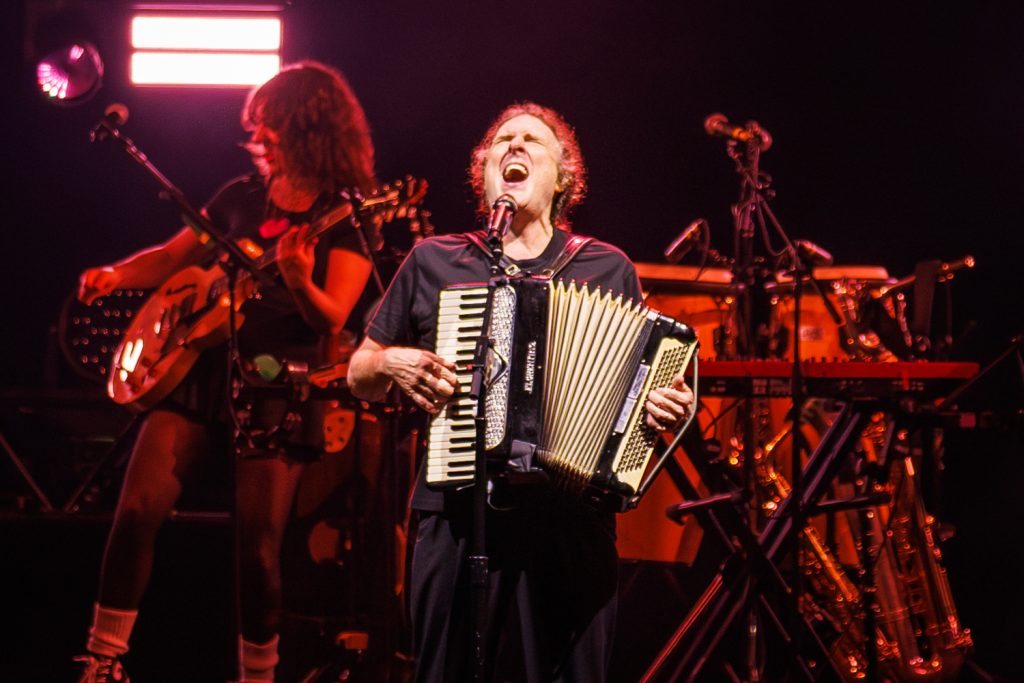 Musician performing with accordion on stage.