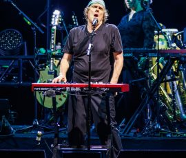 Musician performing on stage with instruments.